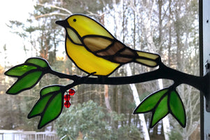 stained glass yellow warbler on a window frame metal branch with red berries